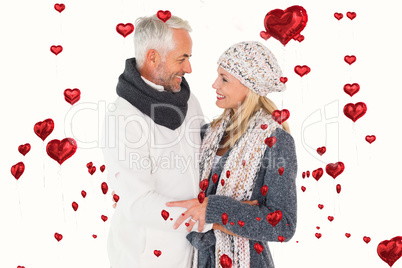 Composite image of happy couple in winter fashion embracing