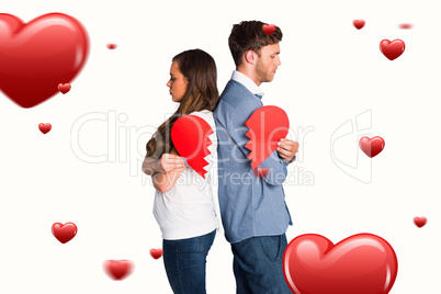 Composite image of side view of young couple holding broken hear