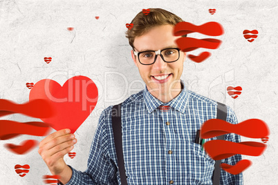 Composite image of geeky hipster holding a heart card