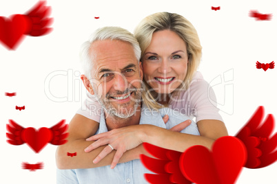 Composite image of smiling couple embracing and looking at camer