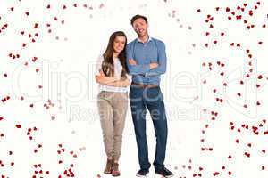 Composite image of smiling young couple with arms crossed