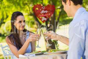 Composite image of couple toasting champagne flutes at an outdoo