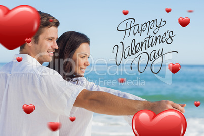 Composite image of romantic couple relaxing on the beach