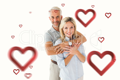 Composite image of happy couple smiling at camera and embracing