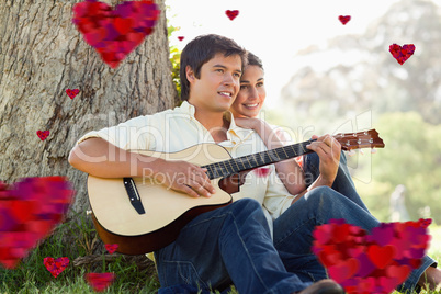 Composite image of man playing the guitar while looking into the