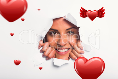 Composite image of young woman looking through paper rip