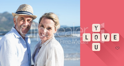 Composite image of happy couple standing on the beach together