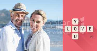 Composite image of happy couple standing on the beach together