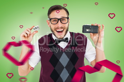 Composite image of geeky hipster holding a retro tape cassette p