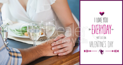 Composite image of couple holding hands at dinner