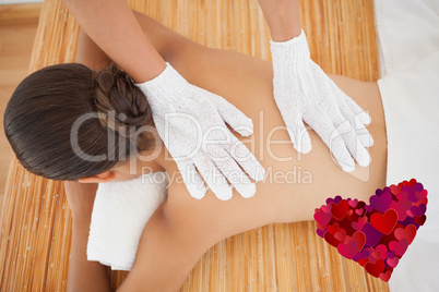 Composite image of beautiful brunette enjoying a back massage