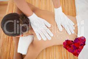 Composite image of beautiful brunette enjoying a back massage