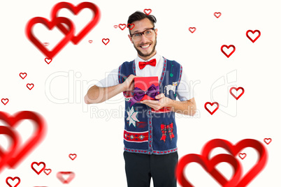 Composite image of geeky hipster offering christmas gift