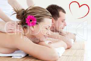 Composite image of relaxed young couple receiving a back massage