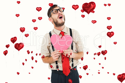 Composite image of geeky hipster crying and holding heart card