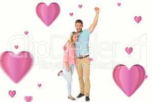 Composite image of attractive couple smiling and cheering