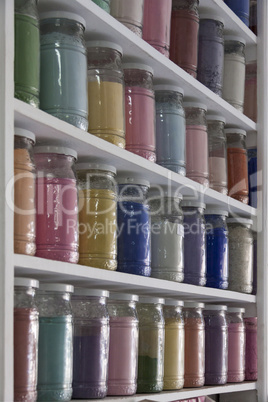 Shelving with glass jars of colorful pigments