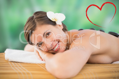 Composite image of beautiful woman receiving stone massage at he