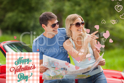 Composite image of cheerful young couple reading map