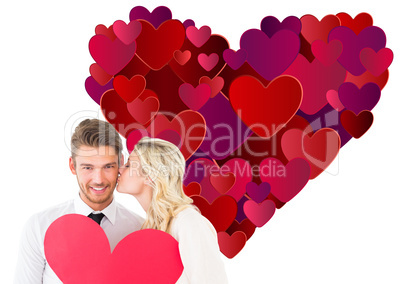 Composite image of attractive young couple holding red heart