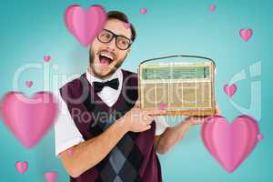 Composite image of geeky hipster holding a retro radio