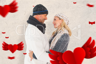 Composite image of happy couple in winter fashion embracing