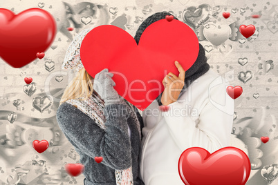 Composite image of couple in winter fashion posing with heart sh