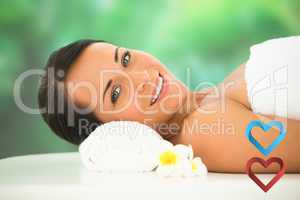 Composite image of beautiful brunette relaxing on massage table