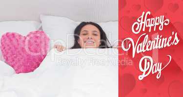 Composite image of woman lying in bed next to a fluffy heart pil