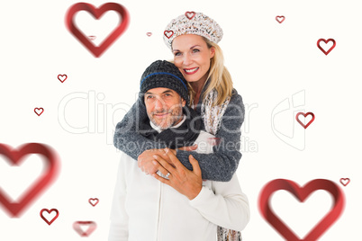 Composite image of happy couple in winter fashion embracing