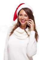 Pretty woman in a Santa hat reading an sms