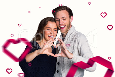 Composite image of happy couple forming heart with hands