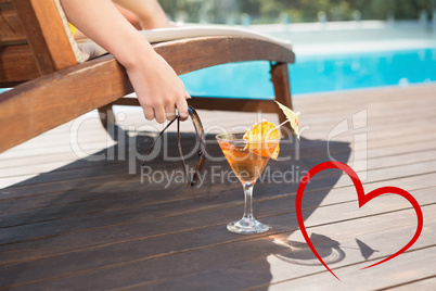 Composite image of tropical juice by swimming pool
