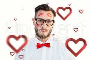 Composite image of geeky hipster with kisses on his face