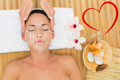 Composite image of smiling brunette enjoying a head massage