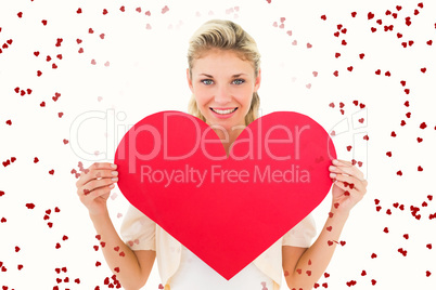 Composite image of attractive young blonde showing red heart