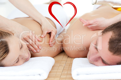 Composite image of relaxed couple receiving a back massage