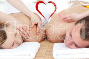 Composite image of relaxed couple receiving a back massage