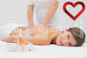 Composite image of attractive young woman receiving back massage