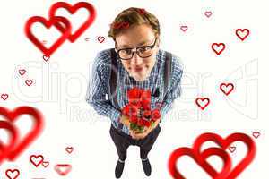 Composite image of geeky hipster holding a bunch of roses