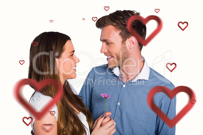 Composite image of man kissing woman as she holds flower