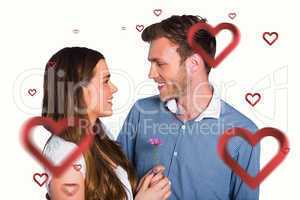 Composite image of man kissing woman as she holds flower