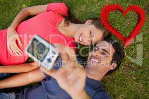 Composite image of man taking a photo with his friend while lyin