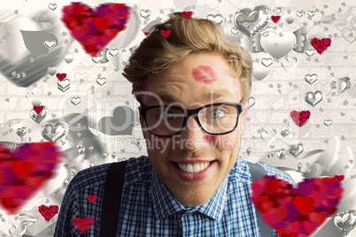 Composite image of geeky hipster covered in kisses