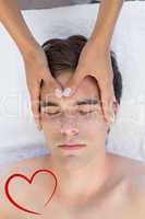 Composite image of man receiving head massage at spa center