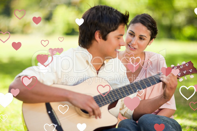 Composite image of man playing the guitar while his friend watch