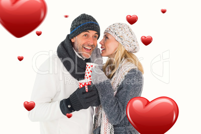 Composite image of happy couple in winter fashion holding mugs