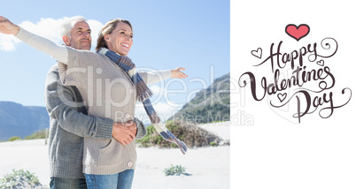 Composite image of carefree couple hugging on the beach in warm