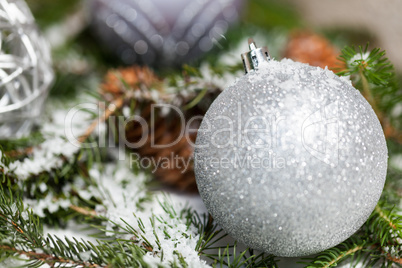 Silver Christmas bauble on a tree with snow