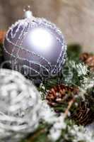 Silver Christmas bauble on a tree with snow
